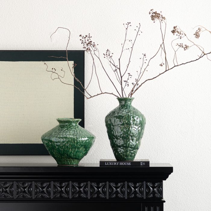 green ceramic vase in home with branch coming out.